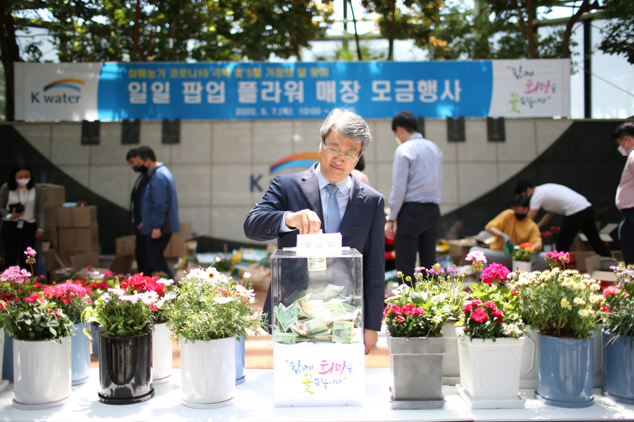 박재현 한국수자원공사 사장이 대전시 대덕구 본사 다목적홀에서 대전 지역 5개 화훼농가가 참여하는 ‘일일 팝업 플라워 매장 모금행사’에 참여해 성금을 내고 있다. [한국수자원공사 제공]