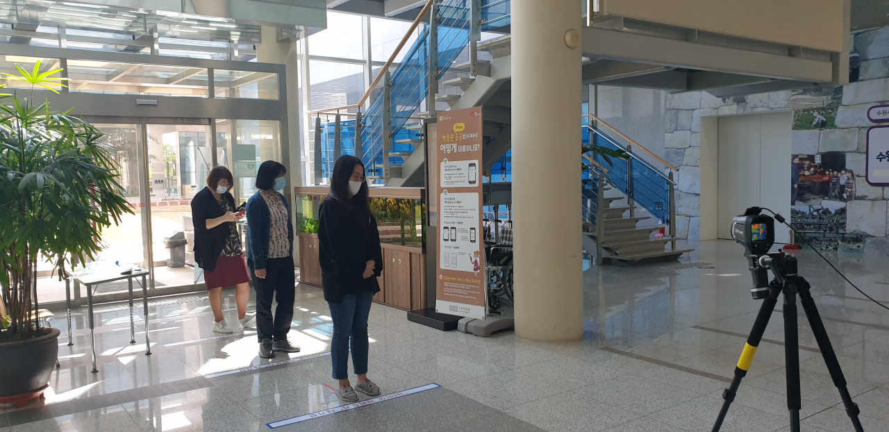 시민들이 박물관에 입장하기 전 거리를 두고 열화상카메라 발열체크를 받고 있다. [수원시 제공]