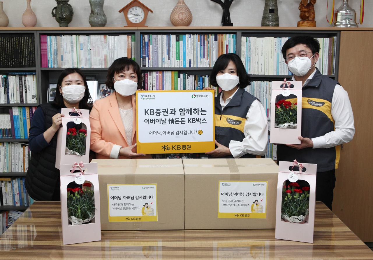 KB증권은 지난 7일 어버이날을 맞아 준비한 카네이션과 식료품 세트를 도봉노인종합복지관에 전달했다. 사진은 KB증권 홍승연 팀장(오른쪽 두 번째)이 도봉노인종합복지관 이은주 관장(왼쪽 두 번째)과 기념사진을 촬영하는 모습. [KB증권 제공]