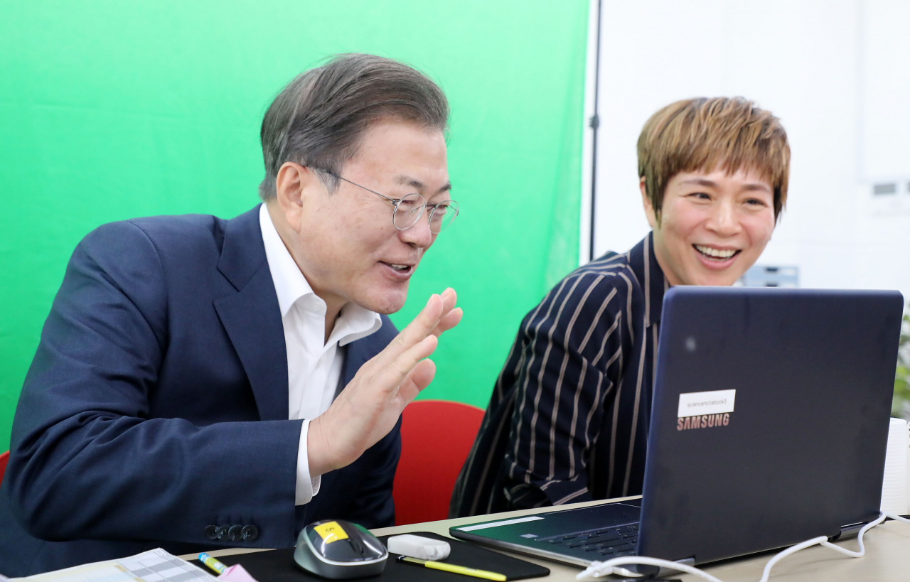 문재인 대통령이 8일 오전 다음 주 등교 개학을 앞둔 서울 용산구 중경고등학교를 방문, 실시간 온라인 수업 중인 학생들과 인사하고 있다. [연합]