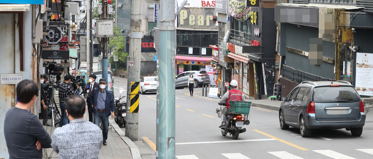 8일 오후 신종코로나 바이러스 감염증(코로나19) 확진자가 다녀간 서울 용산구 이태원 클럽 거리에서 시민들이 취재진을 바라보고 있다. 연합뉴스