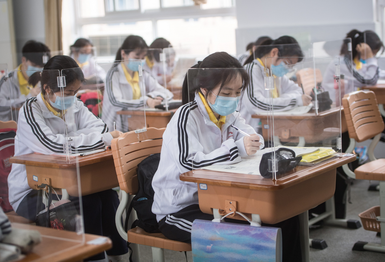 지난달 6일 중국 후베이성 우한의 한 중학교에서 마스크를 착용한 학생들이 신종 코로나바이러스 감염증(코로나19) 예방을 위해 투명 가림막이 설치된 책상에 앉아 공부하고 있다. 연합뉴스
