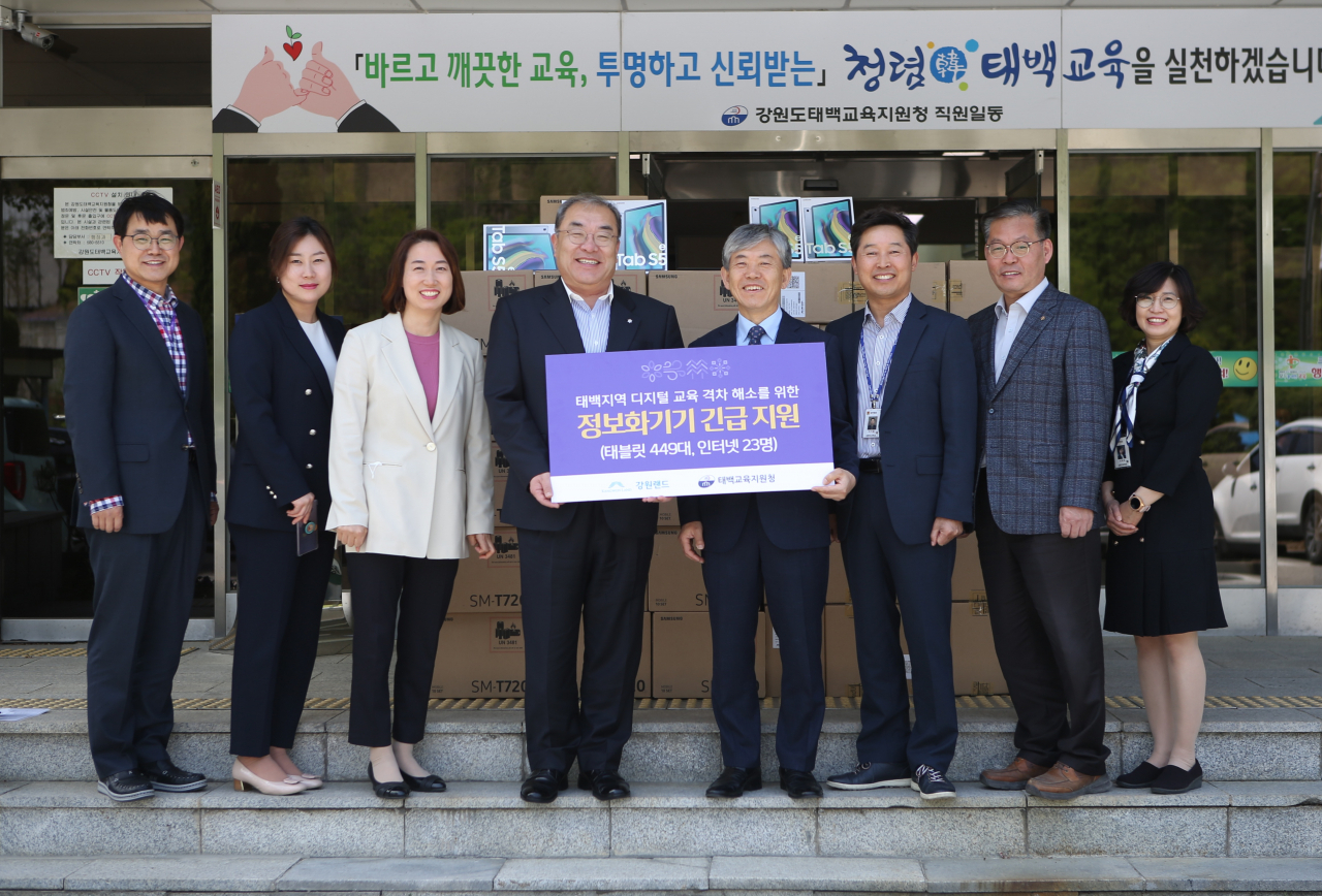 ‘강원랜드의 폐광지역 찾아가는 정보화기기 전달’ : 강원랜드 한형민 부사장(왼쪽 네번째), 태백교육지원청 홍성옥 교육장(오른쪽 네번째)이 폐광지역 학생 온라인학습 위한 태블릿PC를 주고 받은 뒤 기념촬영을 하고 있다.