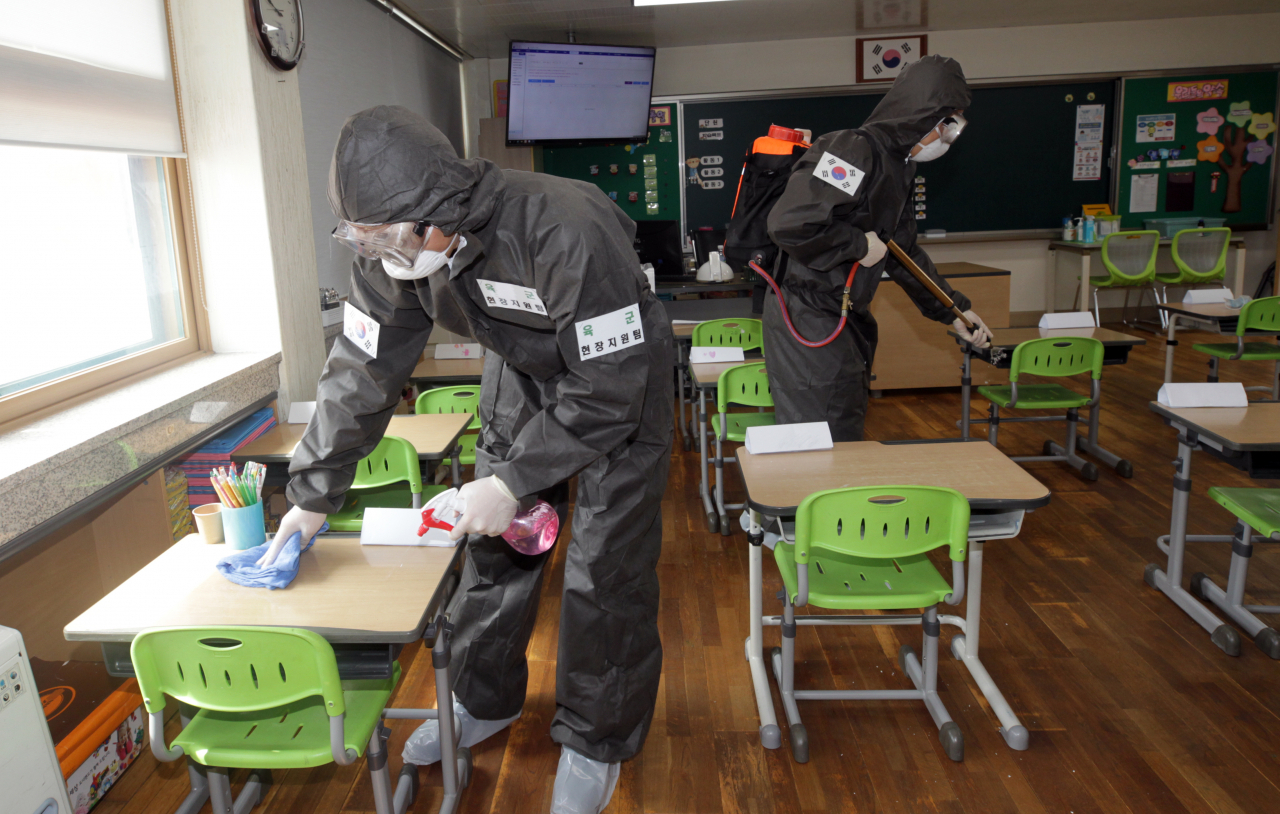 속초시와 양양군 지역 각급 학교 등교수업을 앞두고 학교시설 방역에 나선 육군 8군단 예하 102기갑여단 장병들이 8일 속초 조양초등학에서 방역작업을 하고 있다. [연합]
