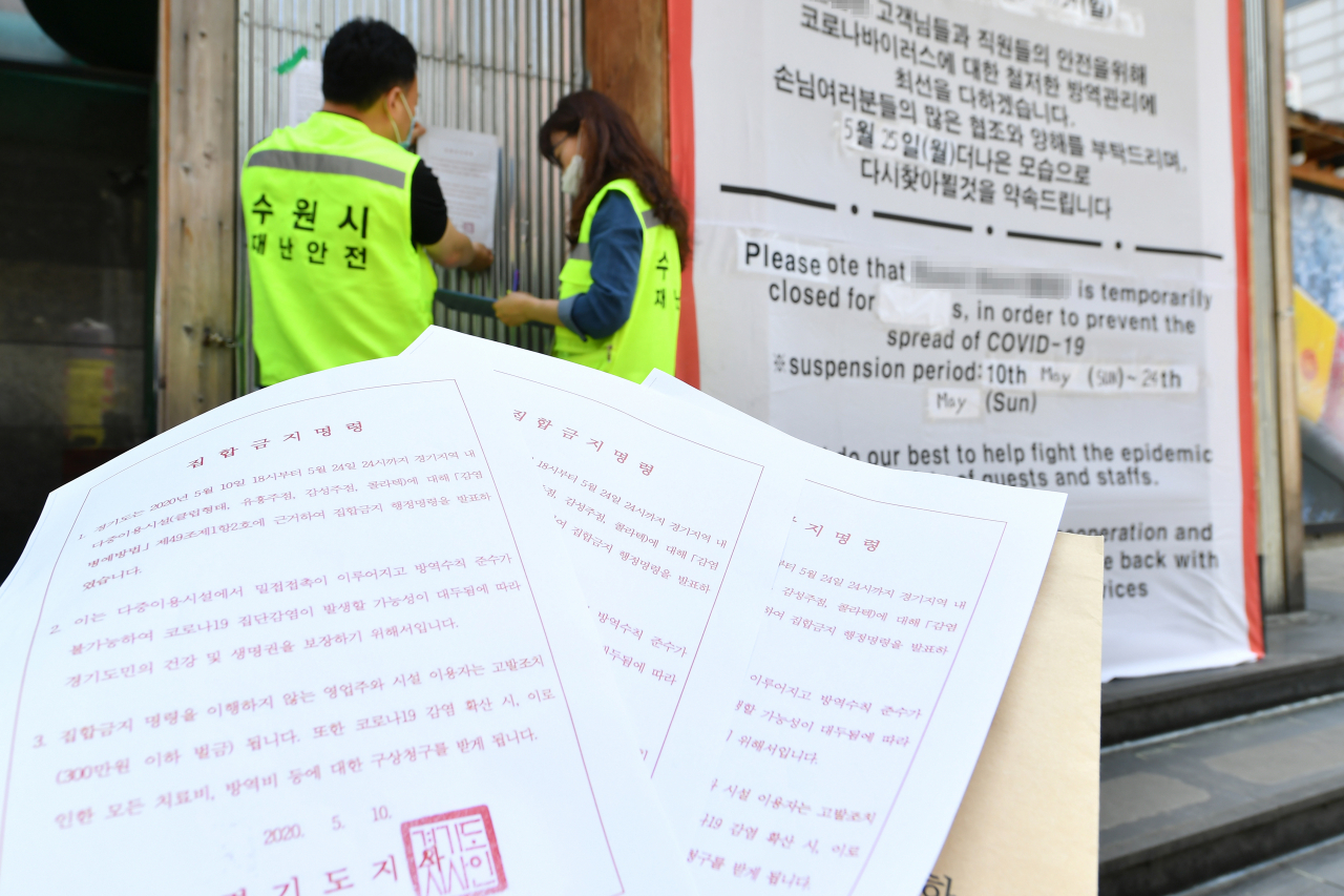 수원시 직원들이 한 유흥주점에 ‘집합금지 명령’ 고지문을 부착하고 있다. [수원시 제공]