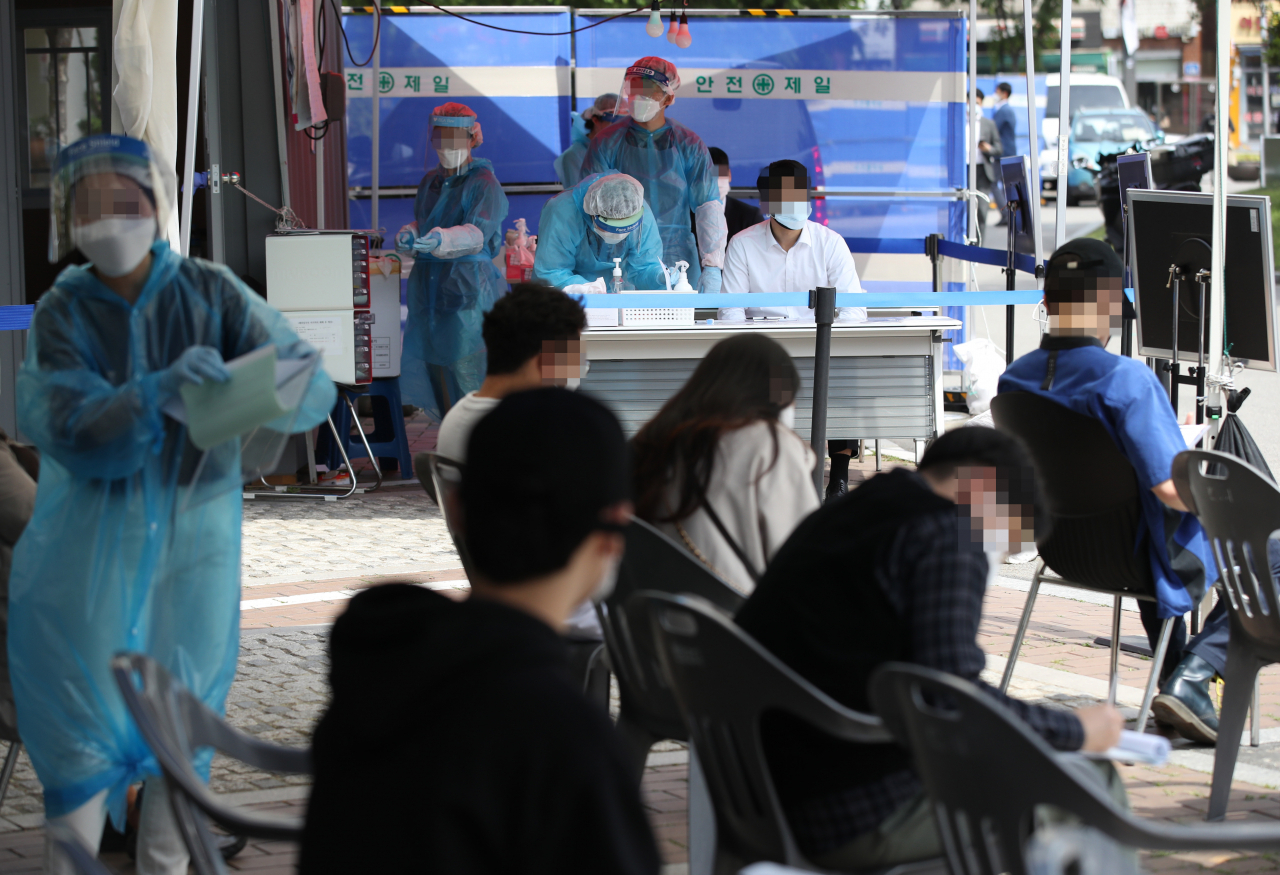‘이태원 클럽발(發)’ 신종 코로나바이러스 감염증(코로나19) 집단 감염이 확산 중인 11일 오후 서울 영등포구 보건소 선별진료소에서 의료진이 검사하고 있다. 검사를 받으러 온 사람들이 상당수 눈에 띈다. [연합]