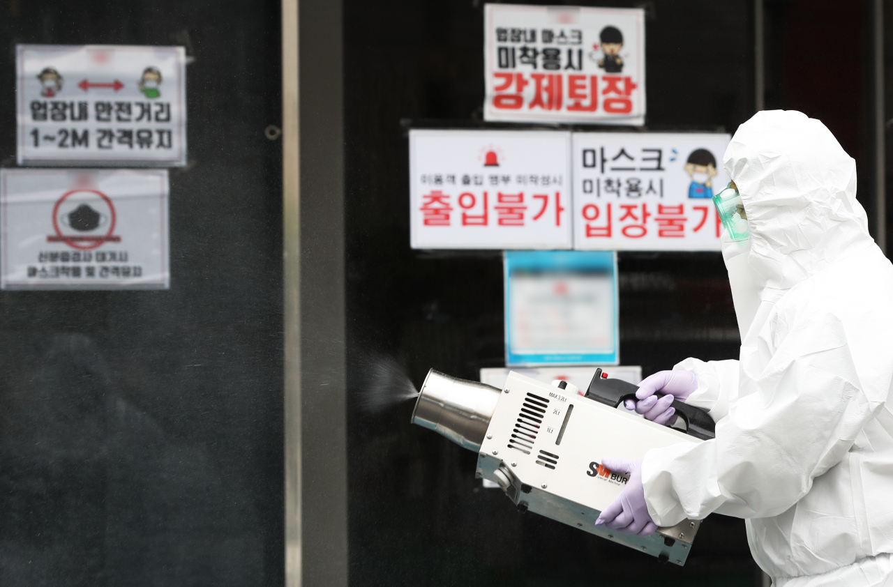 이재명 경기도지사가 도내 모든 클럽 등 유흥시설에 '집합금지' 행정명령을 발표한 10일 오후 경기도 수원시의 한 클럽 앞에서 보건소 관계자가 신종 코로나바이러스 감염증(코로나19) 예방을 위해 방역을 하고 있다. 연합뉴스