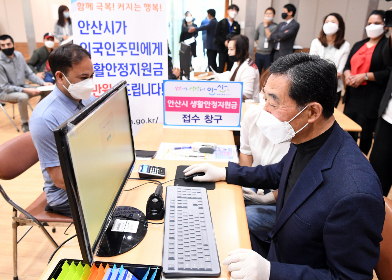 윤화섭 안산시장이 지난 11일 외국인주민지원본부 3층 다목적실에 마련된 외국인 주민 전담 접수창구에서 생활안정지원금 접수를 하고 있다. [안산시 제공]