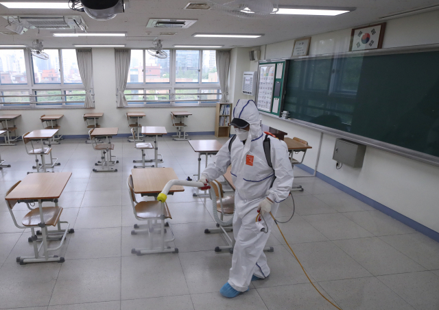신종 코로나바이러스 감염증(코로나19) 집단 감염으로 학교들의 등교 재연기가 발표된 지난 11일 오후 서울 성동구 성수고 3학년 교실에서 방역업체 관계자가 교실 소독을 하고 있다. [연합]