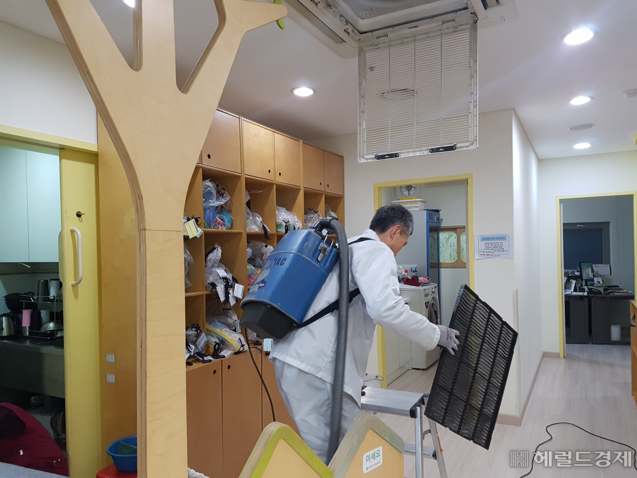 강남구 관계자가 육아종합지원센터의 에어컨 필터를 를 청소하고 있다. [강남구 제공]
