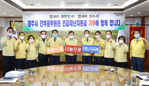 경북 경주시 공무원들이 '코로나19'와 관련해 정부가 지급하는 긴급재난지원금을 기부하기로 하고 지난 11일 기념사진을 찍고 있다. [연합]