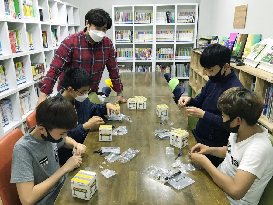 과학체험키트를 전달받은 청소년들이 실내에서 기계기술의 원리를 배울 수 있는 과학체험활동을 펼치고 있다.[한국기계연구원 제공]