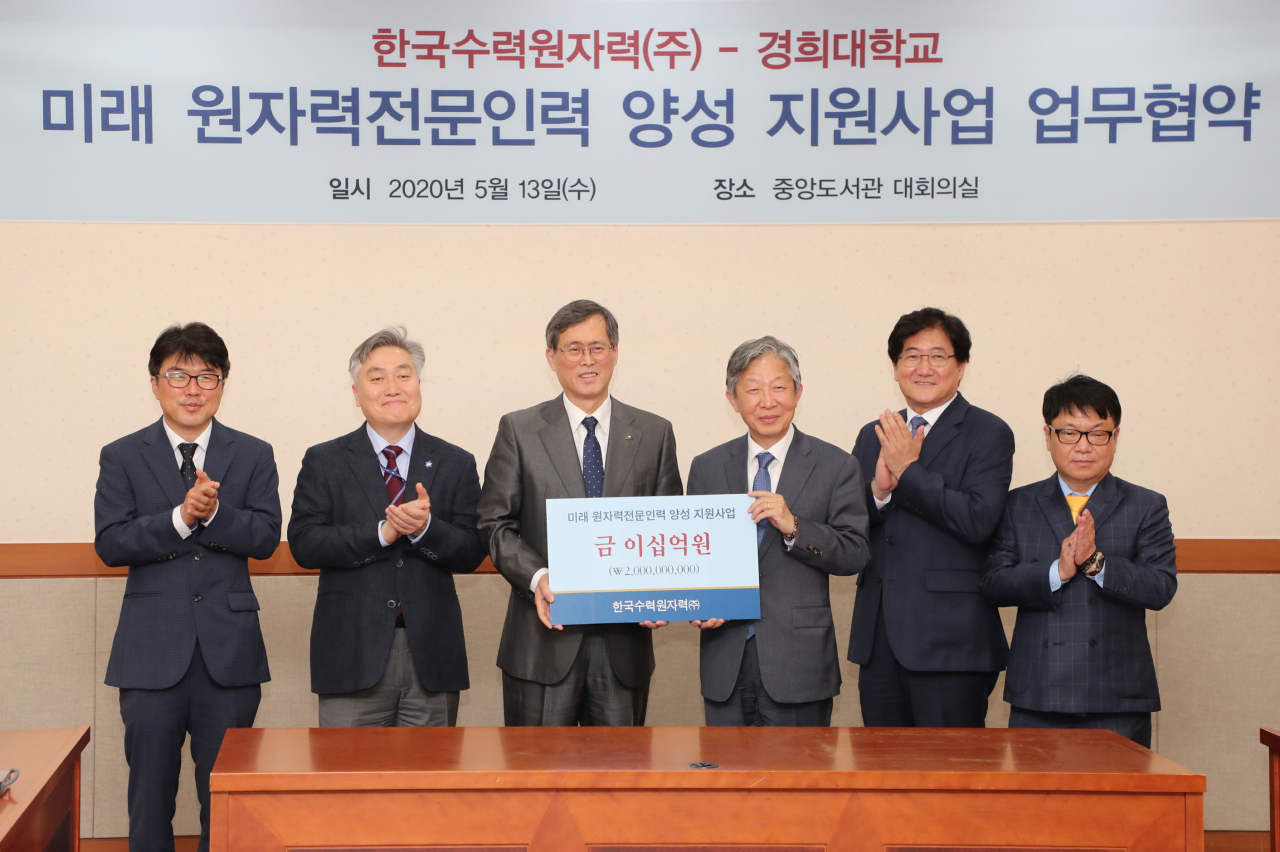 정재훈(왼쪽 세번째) 한국수력원자력 사장이 13일 경기 용인 경희대 국제캠퍼스에서 진행된 미래 원자력 전문인력 양성 지원사업 업무협약에서 기념촬영하고 있다. 정 사장은 이 자리에서 원자력전문인력 양성을 지원하기 위해 20억원 기부했다.［한국수력원자력 제공］