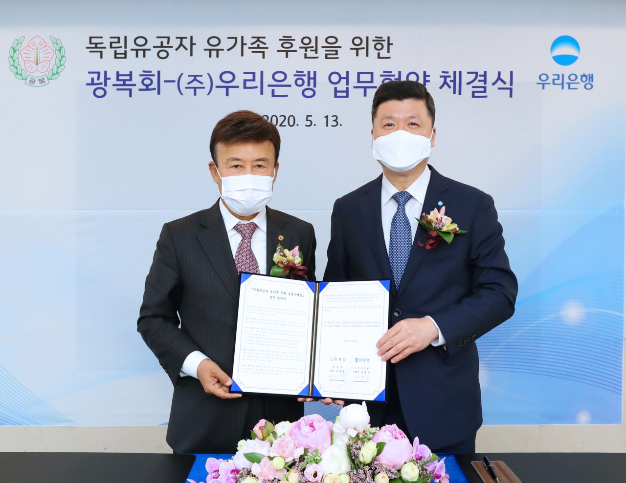 지난 13일 서울 중구 본점에서 권광석(오른쪽) 우리은행장과 김원웅 광복회장이 업무협약에 서명한 뒤 기념촬영을 하고 있다. [우리은행 제공]