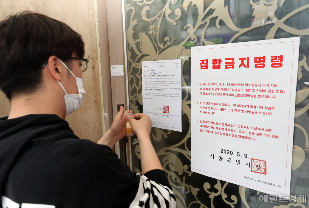 강남구 관계자가 유흥시설 집합금지 행정명령서를 부착하고 있다. [강난구 제공]