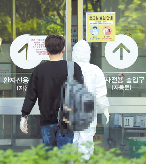 이태원 클럽발 신종 코로나바이러스 감염증(코로나19)이 급증하고 있는 13일 오후 서울 중랑구 서울의료원을 찾은 확진 환자가 입원을 위해 건물로 들어서고 있다. [연합]
