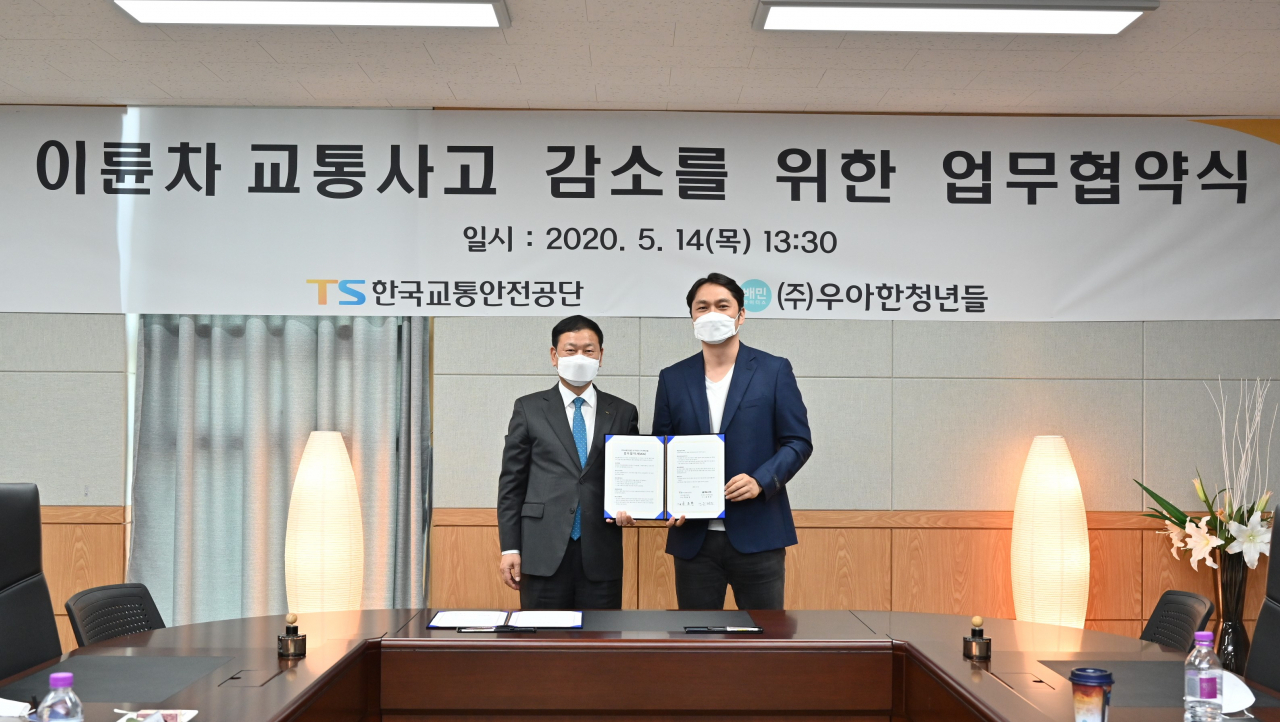 우아한청년들 윤현준 대표 (오른쪽), 한국교통안전공단 김종현 교통안전본부장은 14일 오후 한국교통안전공단 화성체험센터에서 열린 ‘이륜차 교통사고 감소를 위한 업무협약식’에 참석해 협약서에 서명 후 기념사진을 촬영하고 있다. (사진=우아한청년들)