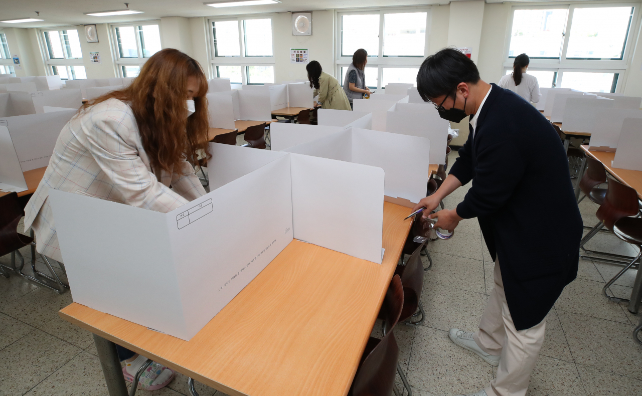 오는 20일 고등학교 3학년 등교 수업을 앞두고 13일 오전 서울 성동구 덕수고등학교에서 영양사 및 교사 등이 급식실에 칸막이를 설치하고 있다. [연합]