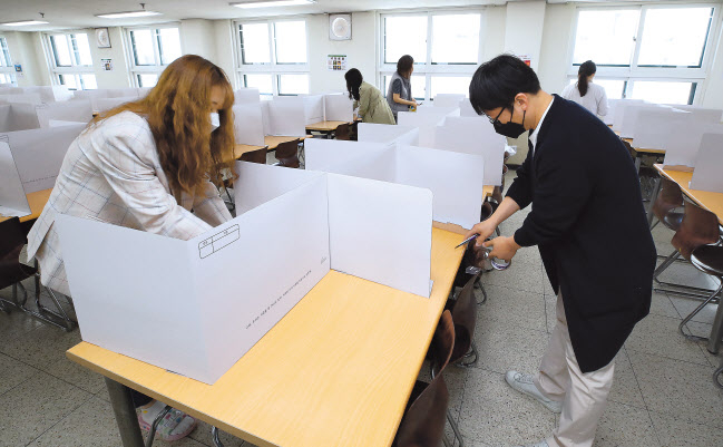 오는 20일 고등학교 3학년 등교수업을 앞두고 13일 오전 서울 성동구 덕수고등학교에서 영양사 및 교사 등이 급식실에 칸막이를 설치하고 있다. [연합]