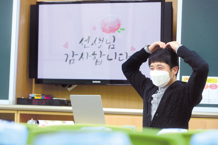 스승의 날일 15일 오전 서울 동작구 보라매초등학교 6학년 1반 박민영 선생님이 텅빈 교실에서 수업을 진행하며 손으로 하트를 하고 있다. 이상섭 기자