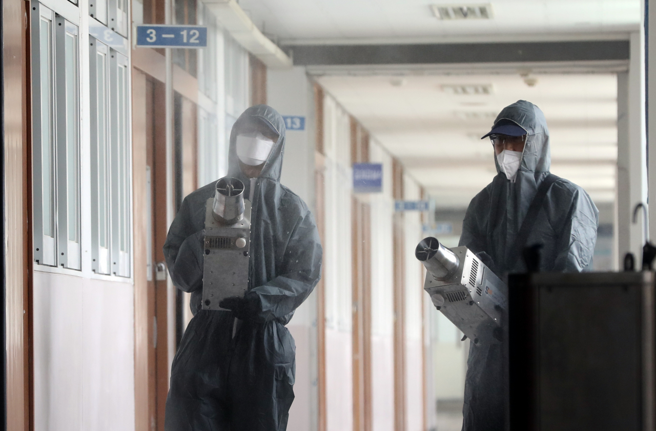 지난 11일 서울 성동구 덕수고등학교에서 관계자들이 고3 학생들의 등교에 대비해 학교시설을 방역하고 있다. 연합뉴스