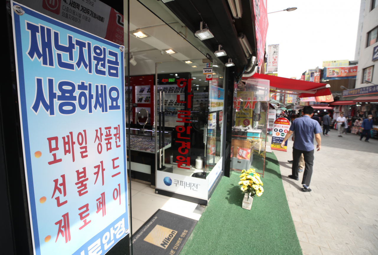 14일 서울 중구 남대문시장 한 상점에 긴급재난지원금 사용 가능 안내문이 붙어 있다. [연합]