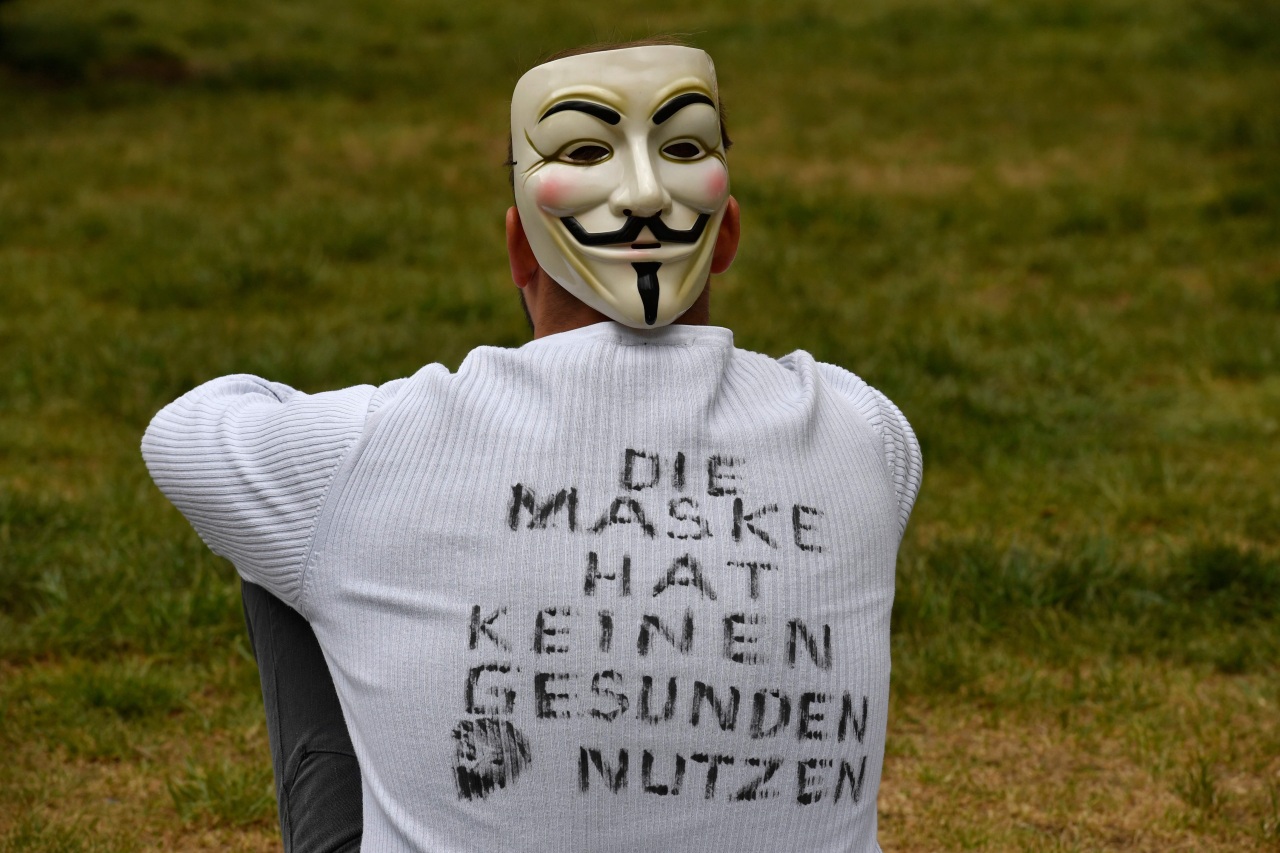 A demonstrator wearing a mask and a T-shirt with inscriptions reading 'The mask has no healthy use' sits in the demo area during a protest against the Corona restrictions in Berlin on May 2, 2020, amid the new coronavirus COVID-19 pandemic.(AFP)