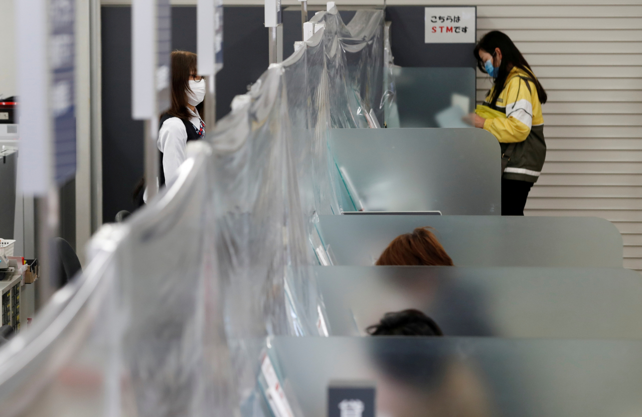 일본 최대 은행인 미쓰비시UFJ의 도쿄 히가시나카노 지점에서 지난달 24일 한 은행원이 마스크를 착용한 채 신종 코로나바이러스 감염증(코로나19) 확산 방지를 위해 비닐 커튼이 쳐진 창구에 서 있다 연합뉴스