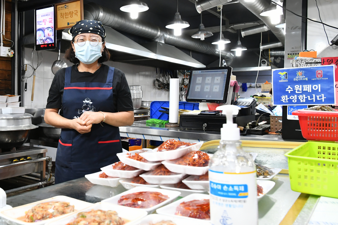 정자시장에서 반찬가게를 운영하는 상인이 마스크를 끼고 손님을 기다리고 있다. [수원시 제공]