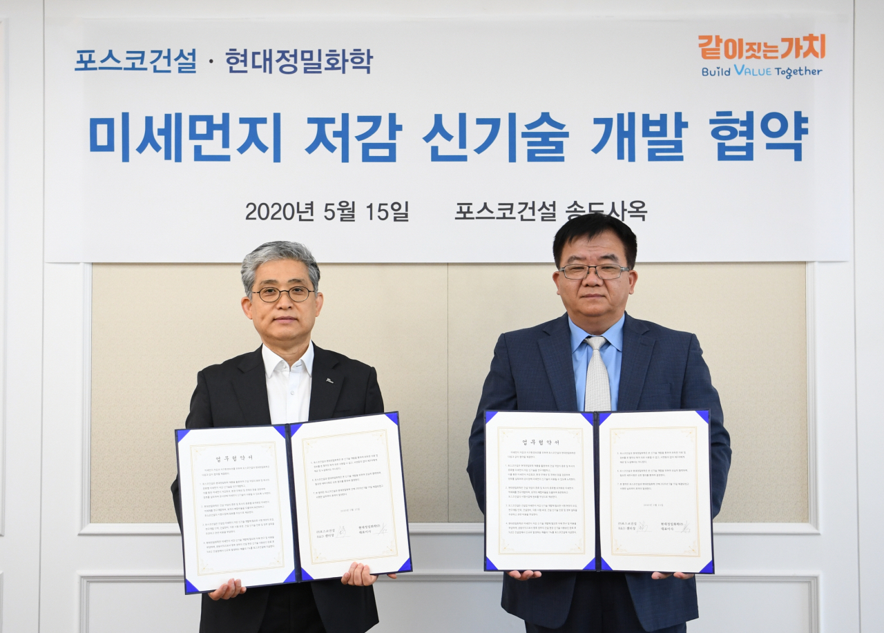 포스코건설 김진호 R&D 센터장(왼쪽), 현대정밀화학 오영국 대표이사가 미세먼지 저감 신기술 개발을 위한 협약을 맺고 기념촬영을 하고 있다. [포스코건설 제공]