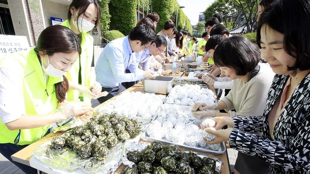 15일 오전 광주 북구청 광장에서 북구청 직원들과 주민들이 제38주년 5·18 민주화운동 기념일을 사흘 앞두고 518인분 주먹밥을 만들고 있다. [연합]