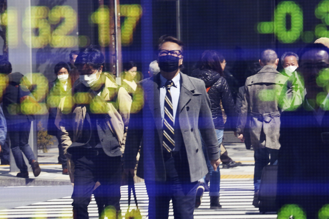 지난 3월 일본 도쿄 증권사 시세판에 비친 시민들의 모습.[AP]