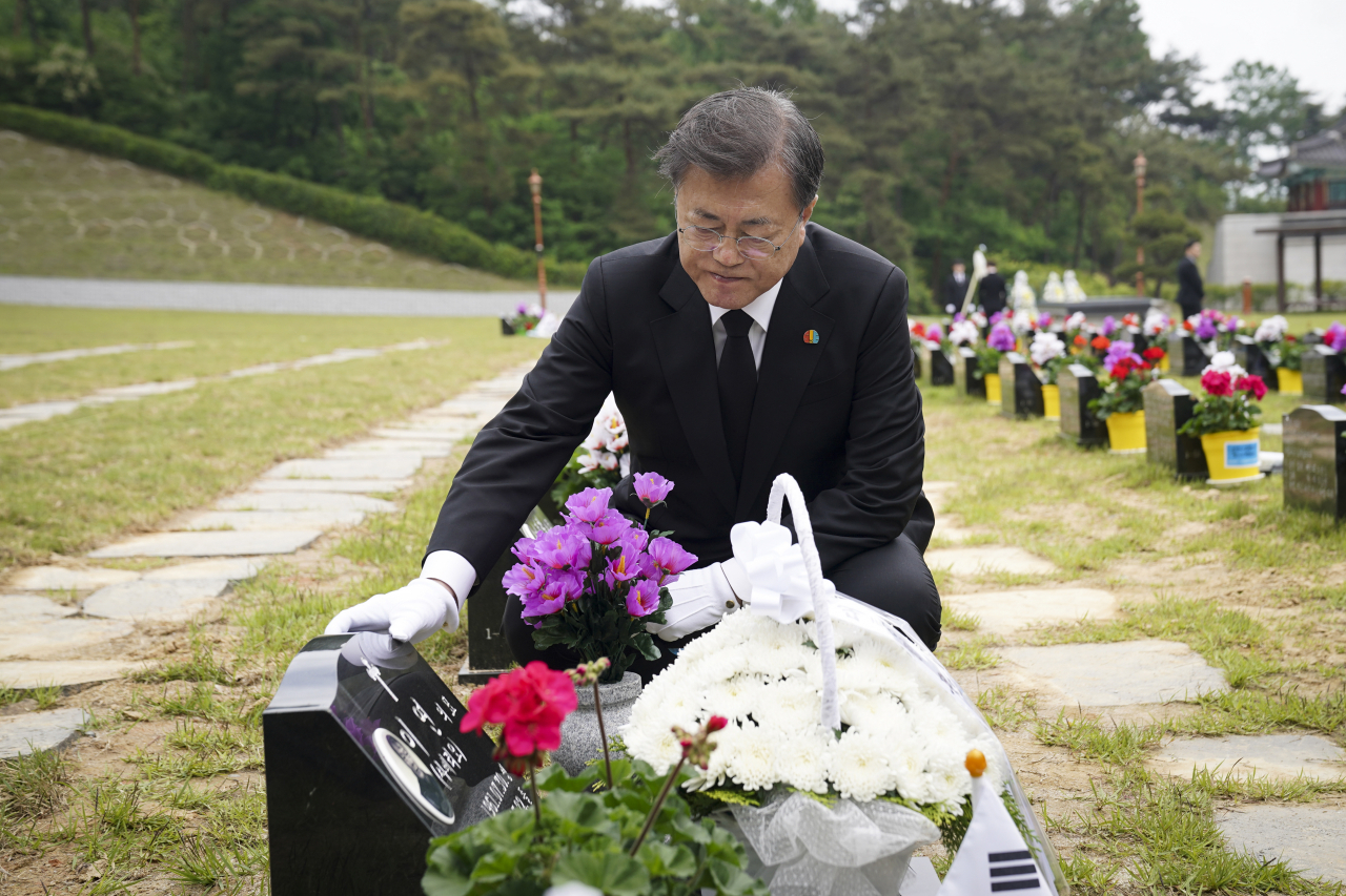 문재인 대통령이 제40주년 5·18 민주화운동 기념일인 18일 광주 북구 5·18 민주묘지 제2묘역에서 고(故) 이연 씨 묘를 찾아 묘비를 어루만지고 있다. 고인은 전남대 1학년에 재학 중이던 1980년 5월 27일 YMCA 회관에서 계엄군과 총격전 중 체포되어 전신 구타를 당했다. 연합뉴스