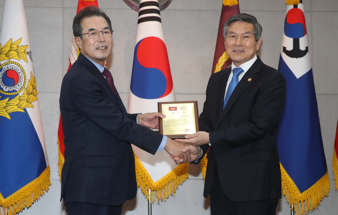 이성희(왼쪽) 농협중앙회장이19일 오후 서울 용산구 국방부 청사에서 정경두 국방부 장관으로부터 6·25 전사자 유가족 시료확보 협력에 대한 감사패를 받고 기념촬영을 하고 있다.［농협중앙회 제공］