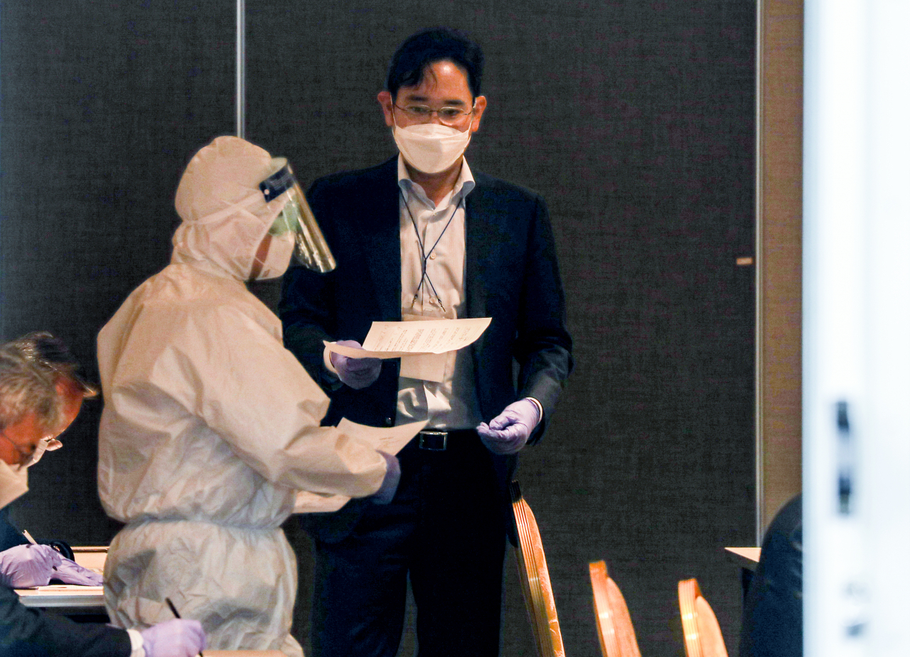 중국 시안 반도체 공장 방문을 마치고 김포공항을 통해 귀국한 이재용 삼성전자 부회장이 19일 오후 김포공항 인근 대기 장소에서 코로나19 검사를 받기 전 문진표를 작성해 제출하고 있다. [연합]