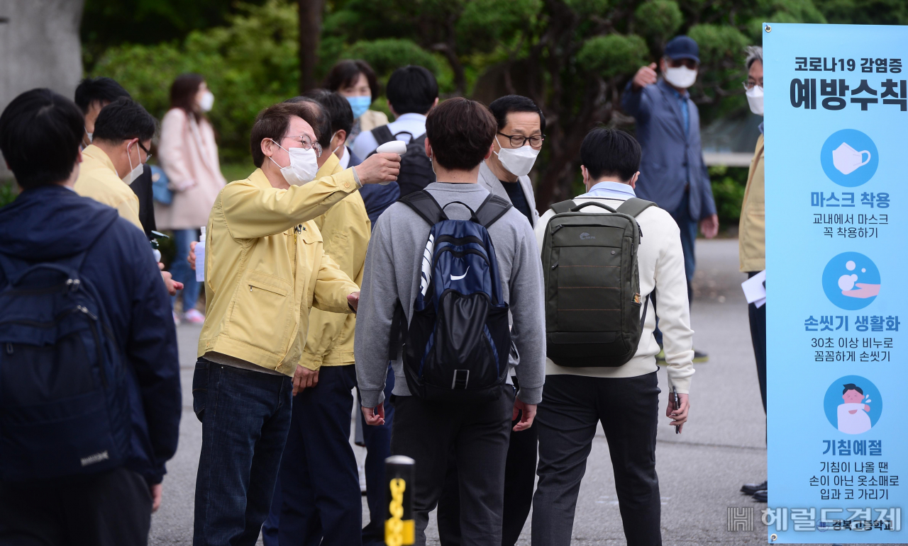 [헤럴드경제=이상섭 기자] 신종 코로나바이러스 감염증(코로나19)의 여파로 미뤄졌던 등교 개학이 80일만에 재개된 가운데 20일 오전 서울 종로구 경복고등학교에서 조희연 서울시 교육감이 등교하는 고3 학생들의 체온을 측정하고 있다. babtong@heraldcorp.com