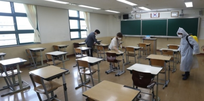 고등학교 3학년 등교 수업을 하루 앞둔 19일 오전 울산시 북구 화봉고등학교에서 교사 등이 책상 소독 등 방역을 하고 있다. [연합]