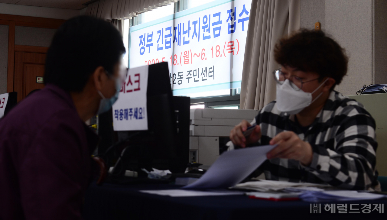 [헤럴드경제=이상섭 기자] 코로나19 대응을 위한 긴급재난지원금 오프라인 신청 첫 날인 18일 오전 서울 마포구 성산 2동 주민센터에서 시민들이 신청서 접수를 위해 줄서 기다리고 있다. 긴급재난지원금을 지역사랑상품권·선불카드로 받으려면 오늘부터 읍·면·동 주민센터를 방문해 신청하면 된다. 온라인으로 접수해온 신용·체크카드 충전 방식은 각 카드사 연계 은행 창구를 통해 방문 신청이 가능하다. 지역사랑상품권·선불카드는 마스크 5부제와 동일한 요일제로 신청할 수 있다. babtong@heraldcorp.com