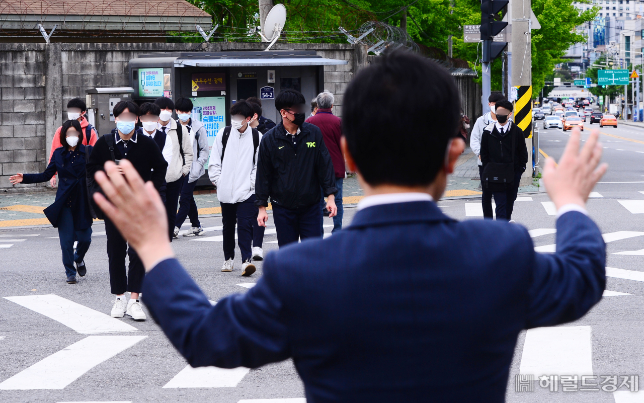 20일 오전 서울 용산구 용산고등학교 고등학교 3학년 학생들이 등교하고 있다. 신종 코로나바이러스 감염증(코로나19) 여파로 인해 80일 만에 등교하는 학생들을 맞이하는 조영상 용산고 교장이 학생들에게 1m 간격을 유지하라고 당부하고 있다. 특별한 상황 변화가 없는 한 오는 27일부터는 나머지 학생들의 등교도 순차적으로 이뤄진다. 박해묵 기자