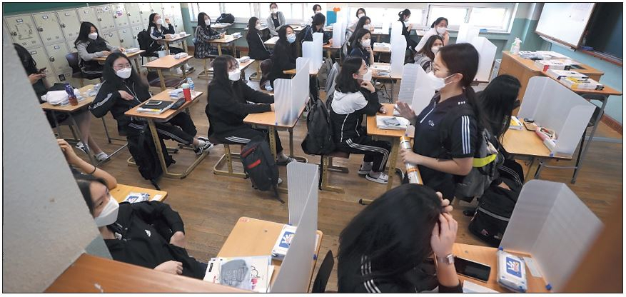 20일 오전 대구시 중구 경북여자고등학교에서 신종 코로나바이러스 감염증(코로나19)으로 개학이 80일 미뤄졌다가 이날 등교한 고3 학생들이 칸막이가 설치된 교실에서 수업 준비를 하고 있다. [연합]