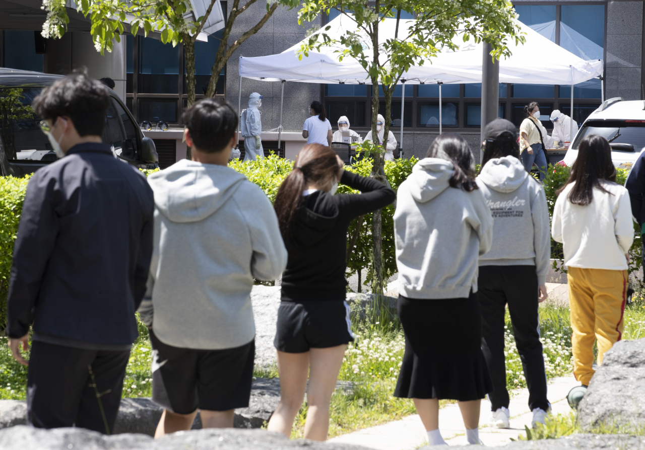 고교생 2명이 신종 코로나바이러스 감염증(코로나19) 확진 판정을 받아 등교가 하루 미뤄진 20일 오후 인천 미추홀구 옹진군청 선별진료소를 찾은 학생들을 비롯한 시민들이 순서를 기다리고 있다. [연합]