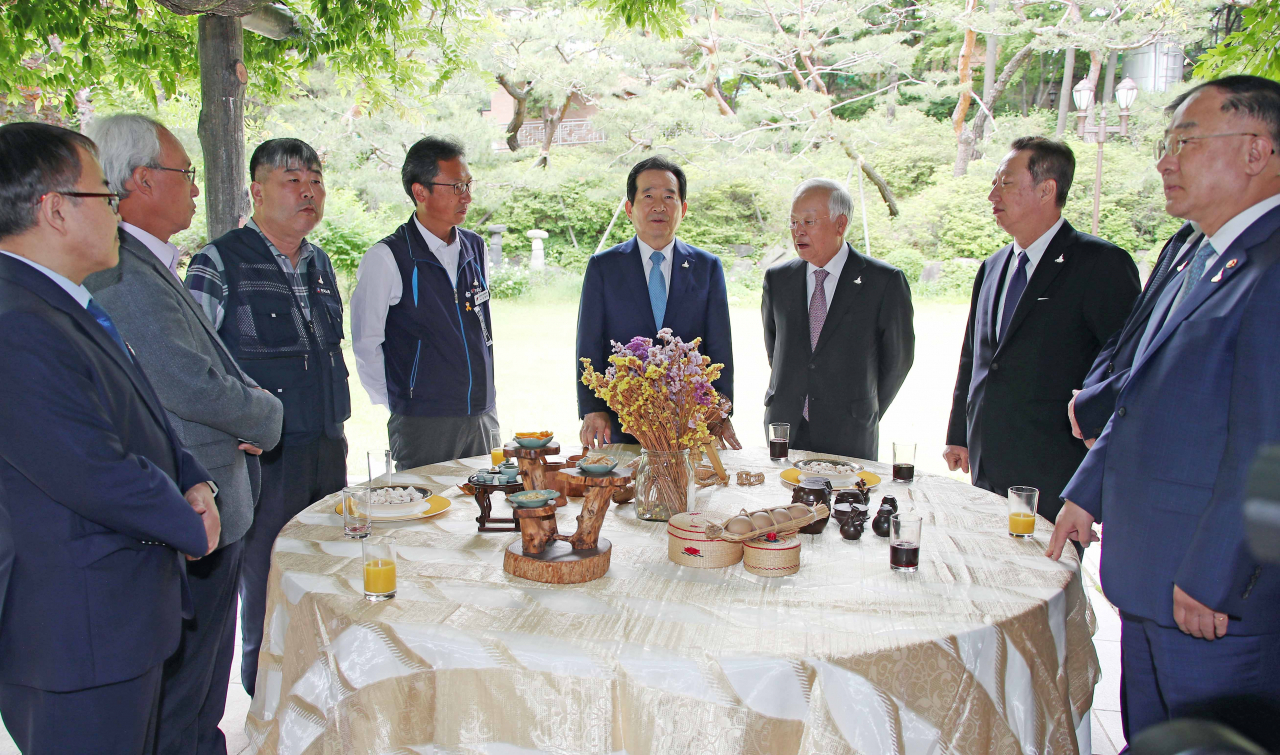 정세균 국무총리가 20일 오후 서울 삼청동 총리공관에서 열리는 '신종 코로나바이러스 감염증(코로나19) 위기 극복을 위한 노사정 사회적 대화' 참석자들과 대화하고 있다. 양대 노총을 포함한 노사정 주체들이 한자리에 모여 국가적 위기 극복 대책을 논의하는 것은 국제통화기금 외환위기 시절인 1998년 노사정위원회 출범 이후 22년 만이다. 오른쪽부터 홍남기 경제부총리 겸 기획재정부 장관, 박용만 대한상공회의소 회장, 정 총리, 김명환 전국민주노동조합총연맹 위원장, 김동명 한국노동조합총연맹 위원장, 문성현 경제사회노동위원회 위원장. [연합]