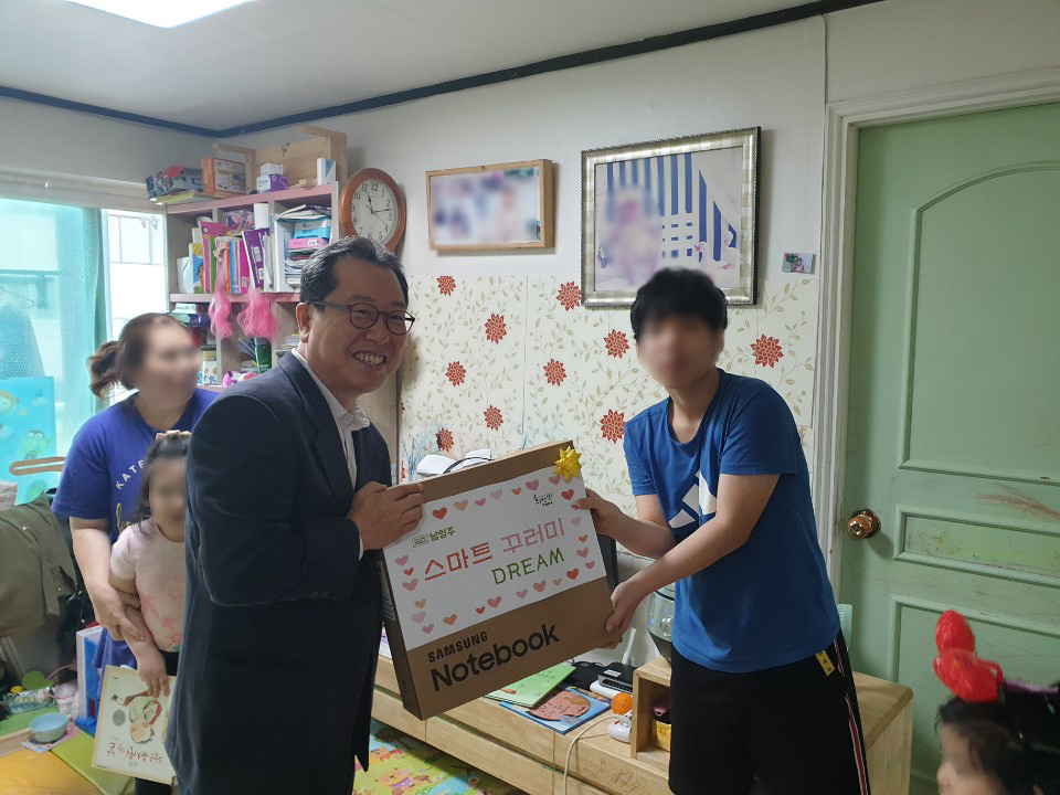 조광한(왼쪽) 남양주시장이 원격수업용 노트북 등을 전달하고 있다.. [남양주시]