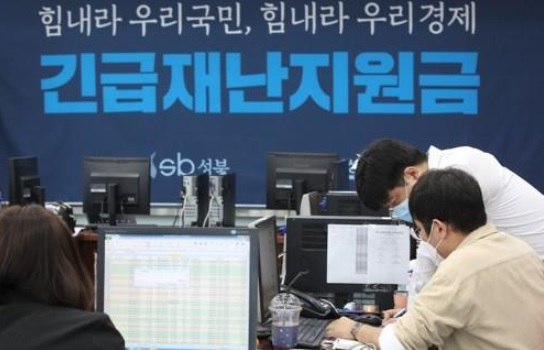 지난 12일 서울 성북구청에서 직원들이 긴급재난지원금 신청과 관련해 안내와 상담을 하고 있다.[연합]