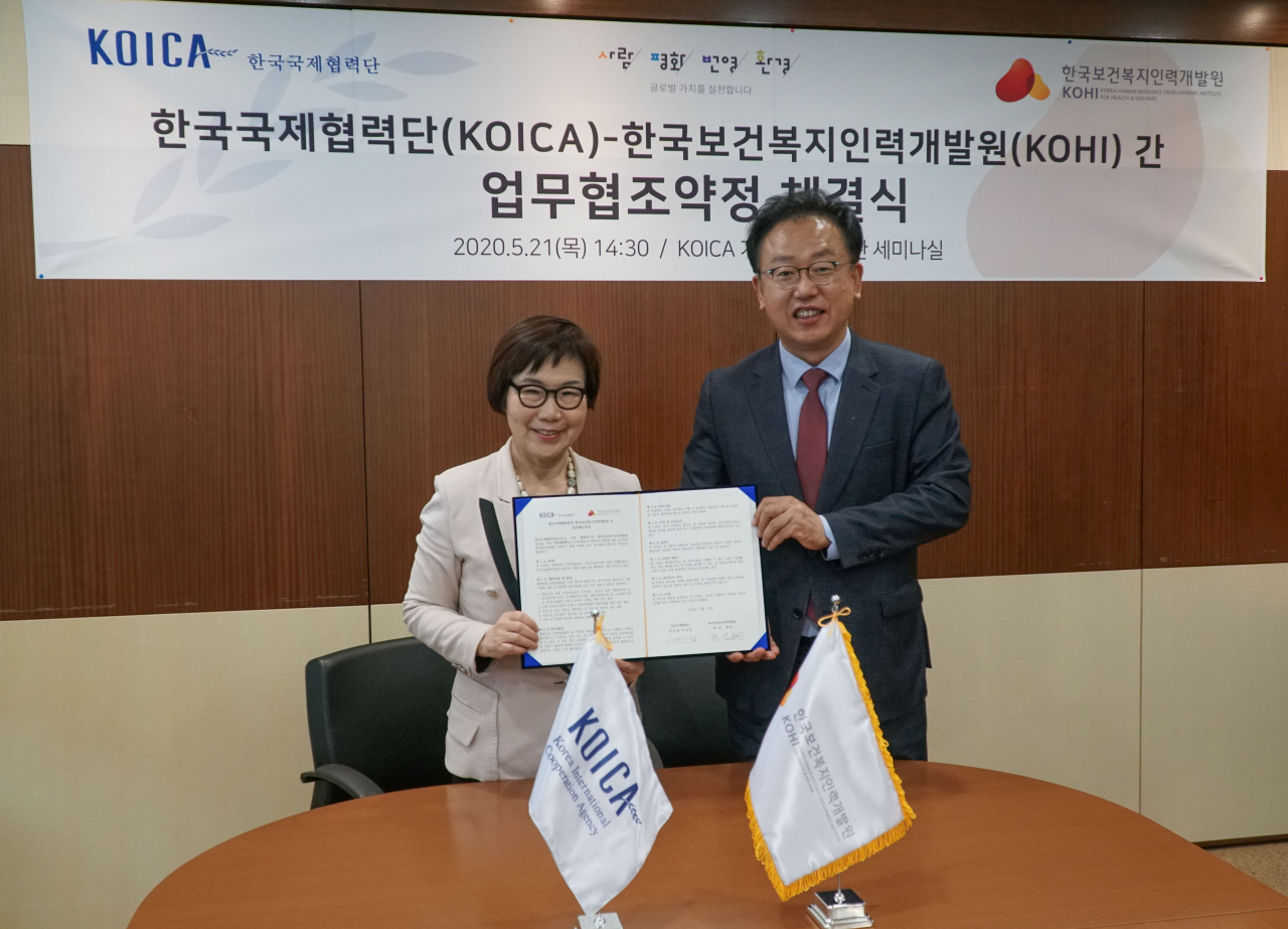 이미경 코이카 이사장(왼쪽)과 허선 한국보건복지인력개발원장(오른쪽)이 21일 경기 성남시 소재 코이카 개발협력역사관에서 감염병 관리 및 위기대응 지식을 갖춘 전문인력 양성에 협력하기 위한 업무협조 약정서에 서명을 하고 기념사진을 촬영하고 있다. [코이카 제공]