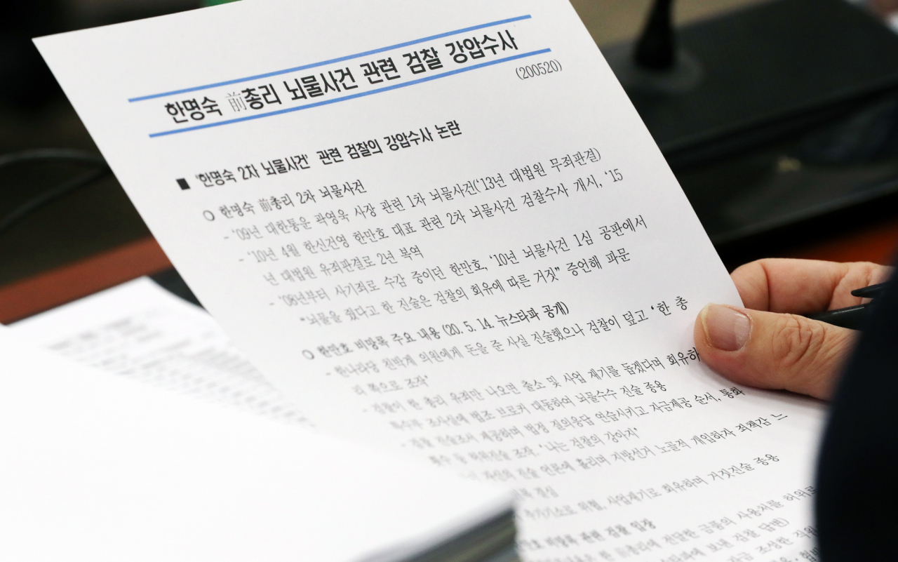 20일 오전 서울 여의도 국회에서 열린 법제사법위원회 전체회의에서 더불어민주당 한 의원이 한명숙 전 국무총리 뇌물사건 관련 자료를 살펴보고 있다. [연합]