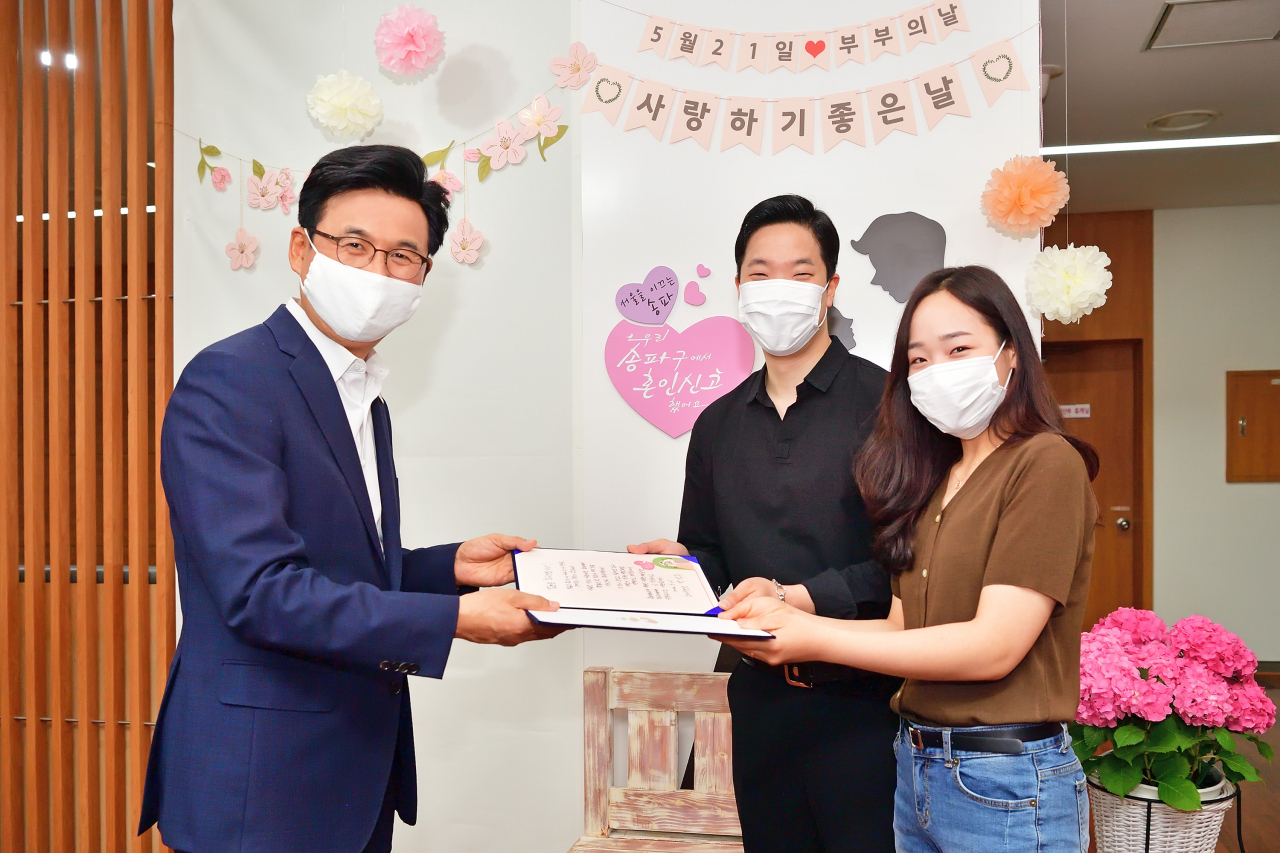 ‘부부의 날’ 첫 혼인신고한 부부에게 박성수 송파구청장이 직접 쓴 축하 편지를 전달하고 있다. [송파구 제공]