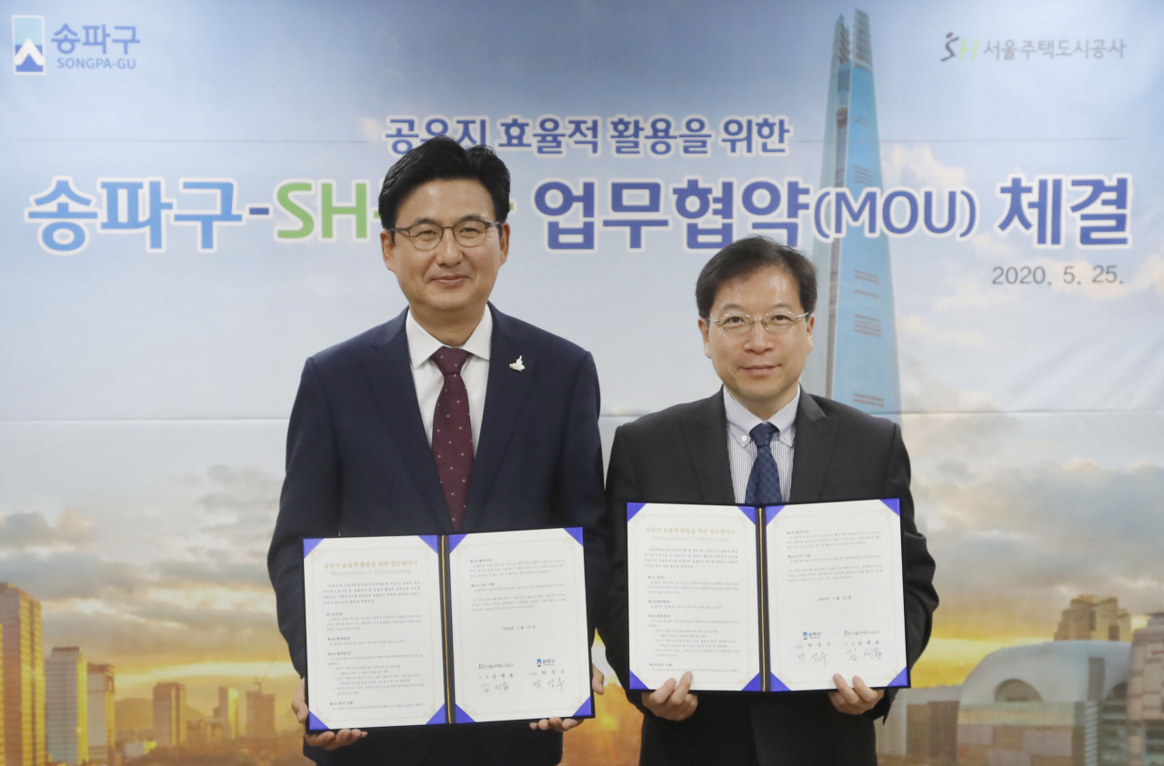 박성수(왼쪽) 송파구청장과 김세용 서울주택도시공사 사장이 지난 25일 송파구청에서 ‘공유지 효율적 활용을 위한 업무협약’을 맺은 후 협약서를 들어보이고 있다. [송파구 제공]