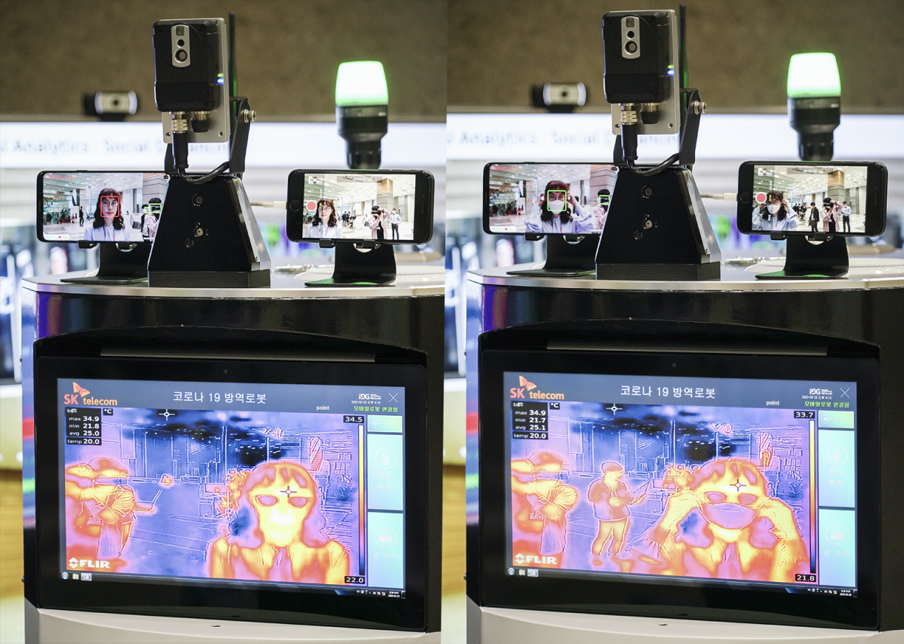 SK텔레콤과 한국오므론제어기기는 26일 코로나19 방역로봇을 공동 개발했다고 밝혔다. 사진은 코로나19방역로봇이 출입객의 체온과 마스크 착용 여부를 검사하고 있는 모습. [SK텔레콤 제공]