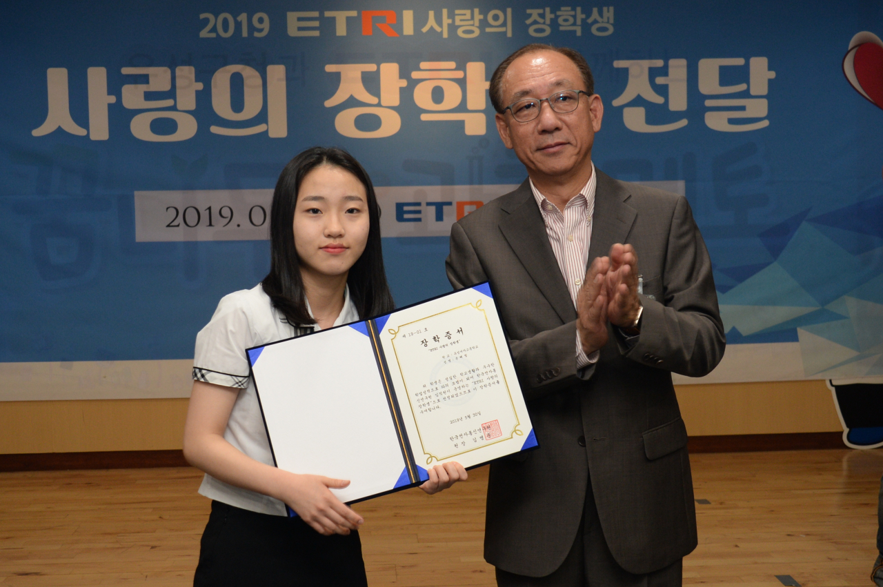 2019년도 사랑의 장학금 전달식에서 김명준(오른쪽) ETRI 원장이 연구원들이 모금한 장학금 및 장학증서를 전달하는 모습.[ETRI 제공]